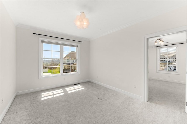 empty room with plenty of natural light, ornamental molding, and carpet flooring