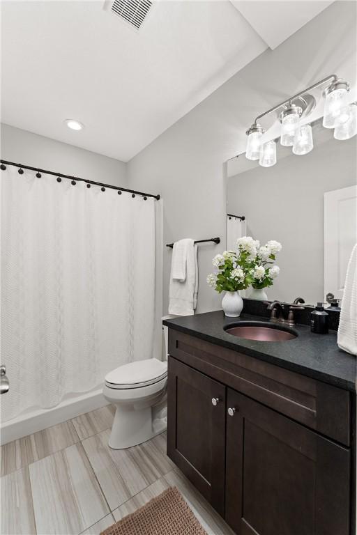 full bath with toilet, shower / tub combo, visible vents, and vanity