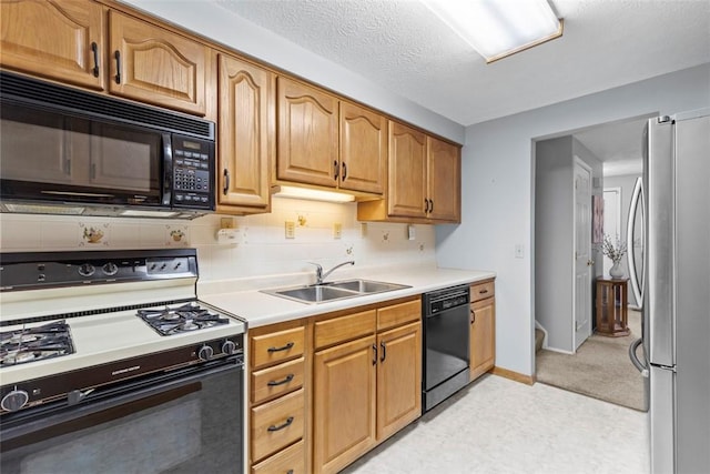 kitchen with a sink, baseboards, light countertops, backsplash, and black appliances