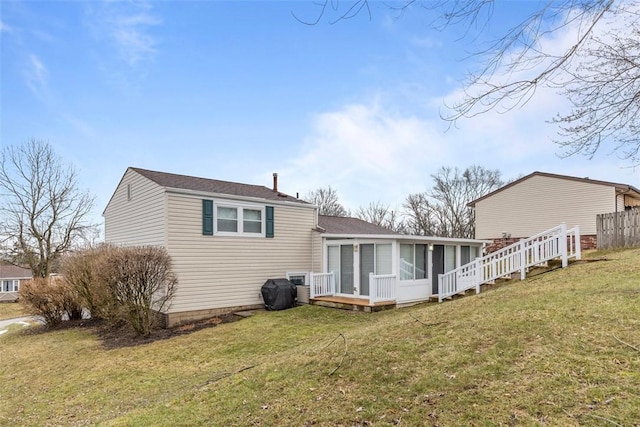 back of property with a sunroom and a yard