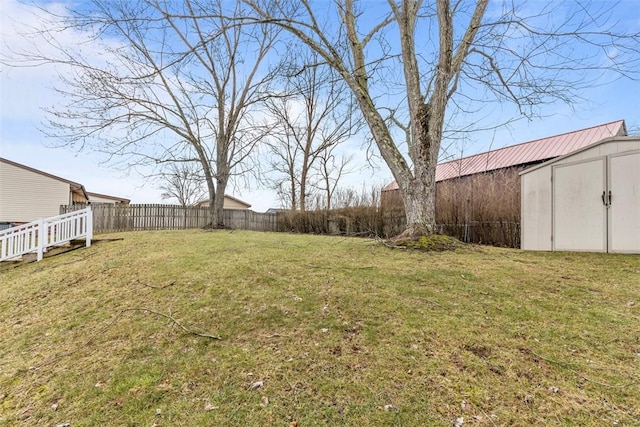 view of yard featuring an outbuilding, fence, and a storage shed