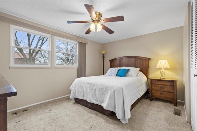 bedroom with carpet floors, baseboards, visible vents, and a ceiling fan