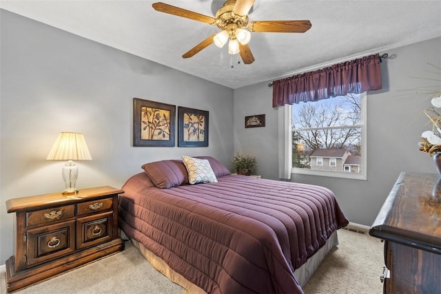 bedroom with a textured ceiling, a ceiling fan, visible vents, baseboards, and carpet