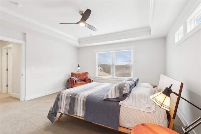 bedroom with baseboards, a raised ceiling, a ceiling fan, and light colored carpet