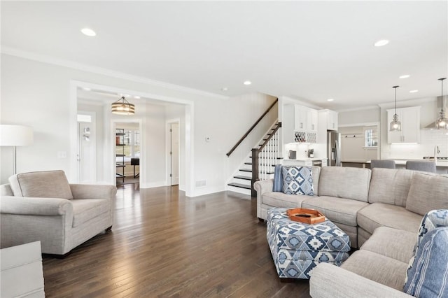 living area featuring recessed lighting, baseboards, stairs, dark wood-style floors, and crown molding