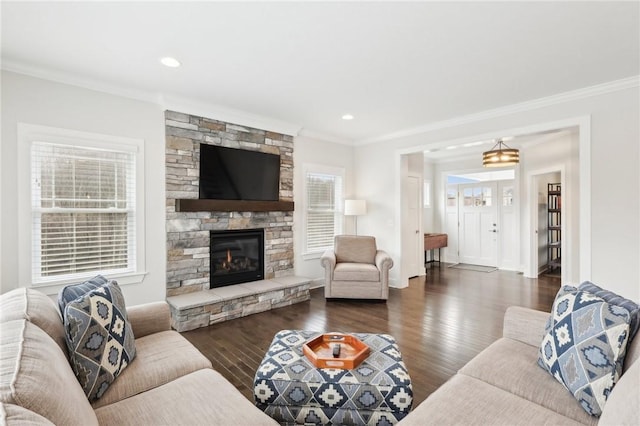 living room featuring crown molding, recessed lighting, dark wood finished floors, and a stone fireplace