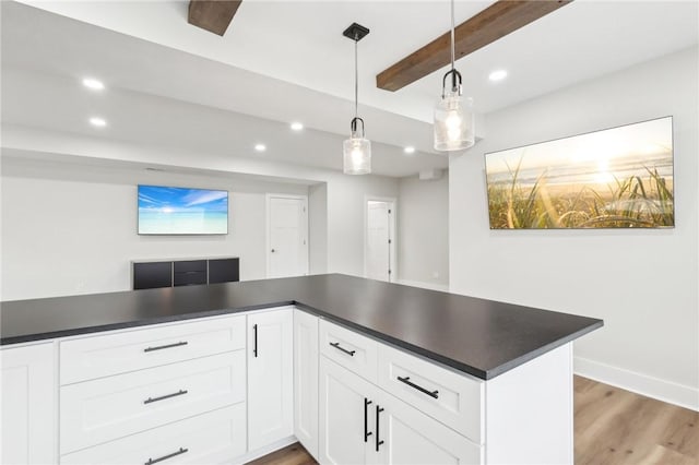 kitchen featuring dark countertops, beam ceiling, and wood finished floors