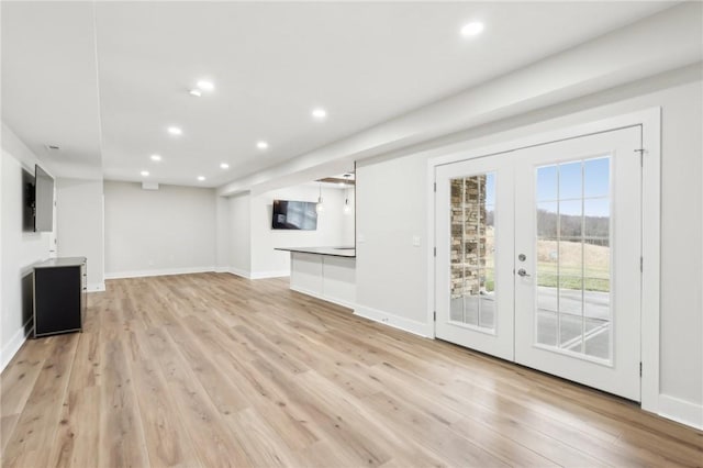 unfurnished living room with light wood-type flooring, recessed lighting, baseboards, and french doors