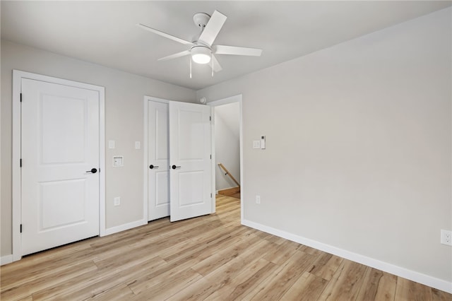 unfurnished bedroom with baseboards, a ceiling fan, and light wood-style floors