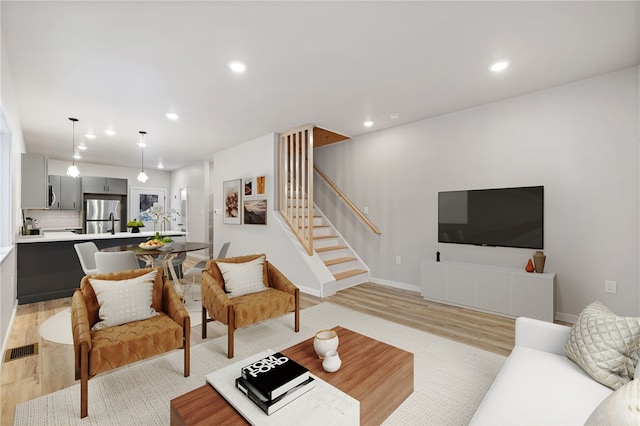 living room with light wood finished floors, stairs, visible vents, and recessed lighting