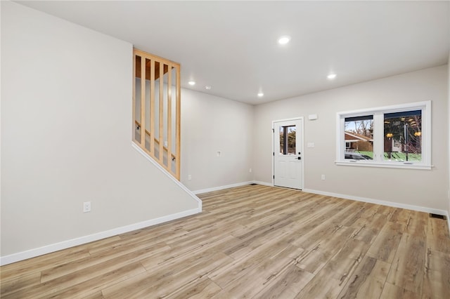 interior space featuring baseboards, stairway, recessed lighting, and light wood-style floors