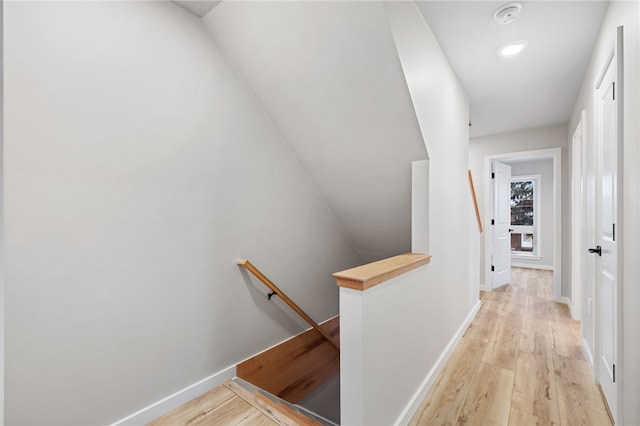 hallway with light wood-style floors, recessed lighting, baseboards, and an upstairs landing