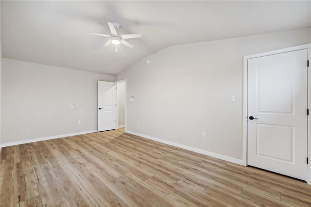 empty room featuring lofted ceiling, ceiling fan, light wood finished floors, and baseboards