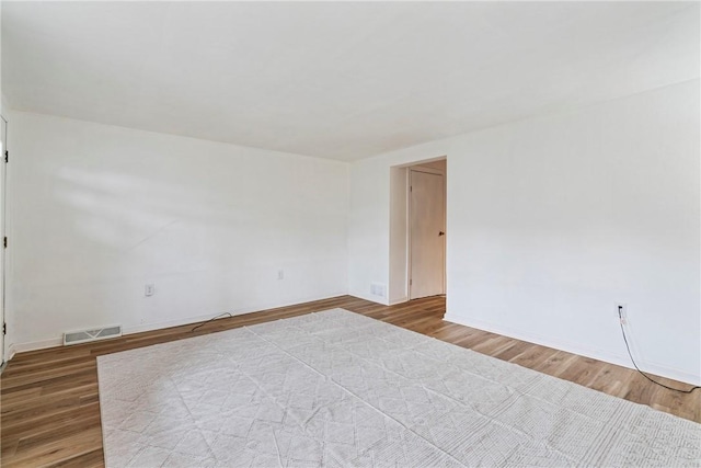 unfurnished room featuring visible vents and wood finished floors