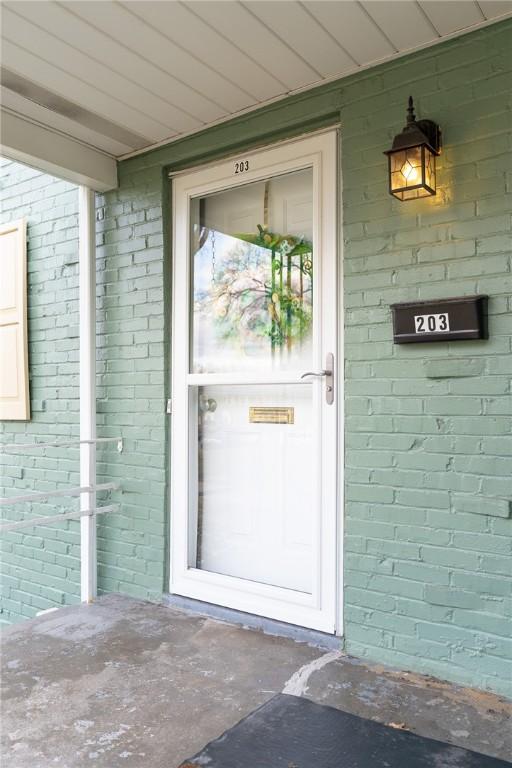 view of exterior entry featuring brick siding