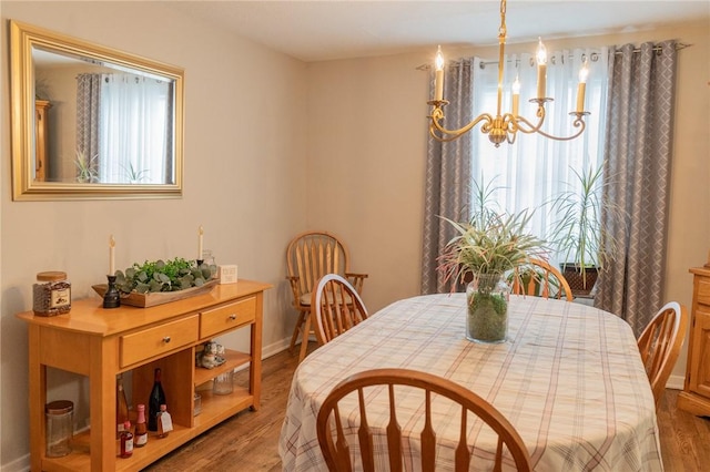 dining room featuring wood finished floors, an inviting chandelier, and plenty of natural light