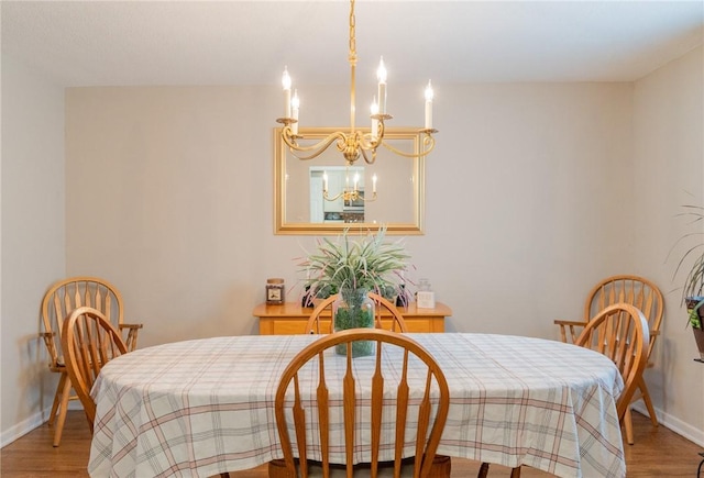 dining area featuring light wood finished floors, an inviting chandelier, and baseboards