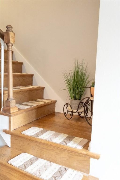 stairs featuring wood finished floors
