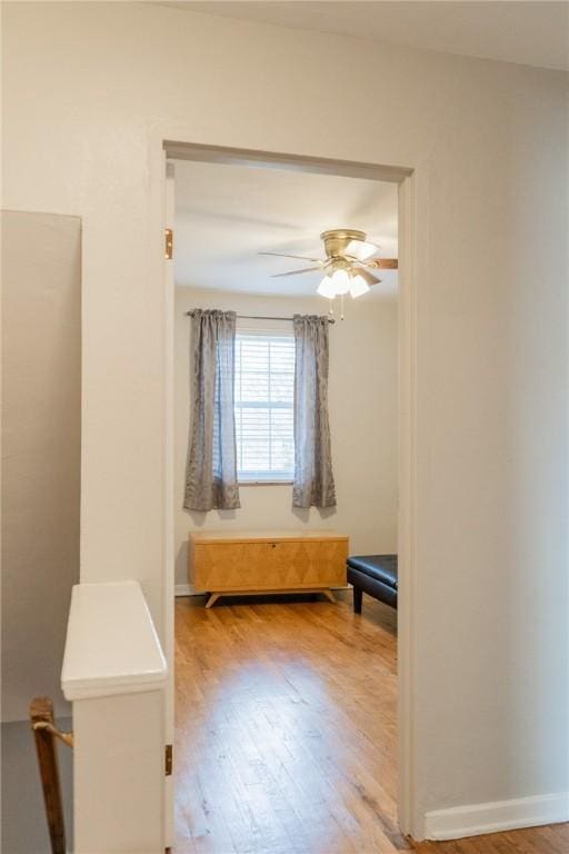 unfurnished bedroom with ceiling fan, wood finished floors, and baseboards