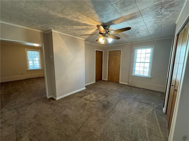 unfurnished bedroom featuring ornamental molding, carpet, multiple windows, and baseboards