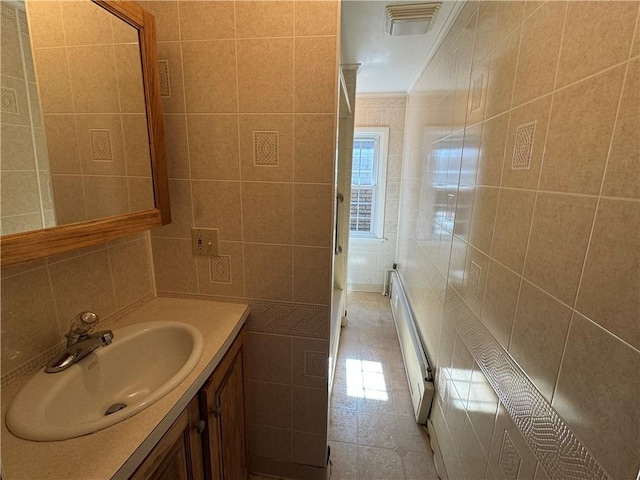 bathroom featuring visible vents, vanity, tile walls, tile patterned floors, and crown molding