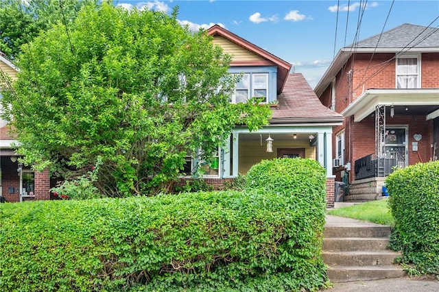 view of front of house with a porch and brick siding