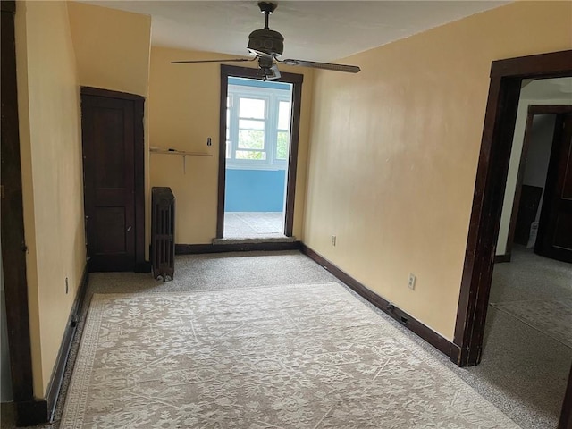 unfurnished room featuring a ceiling fan, carpet flooring, and baseboards