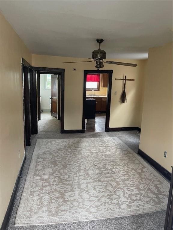 unfurnished room featuring ceiling fan and baseboards