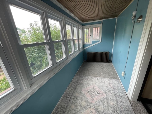 unfurnished sunroom featuring radiator and wooden ceiling