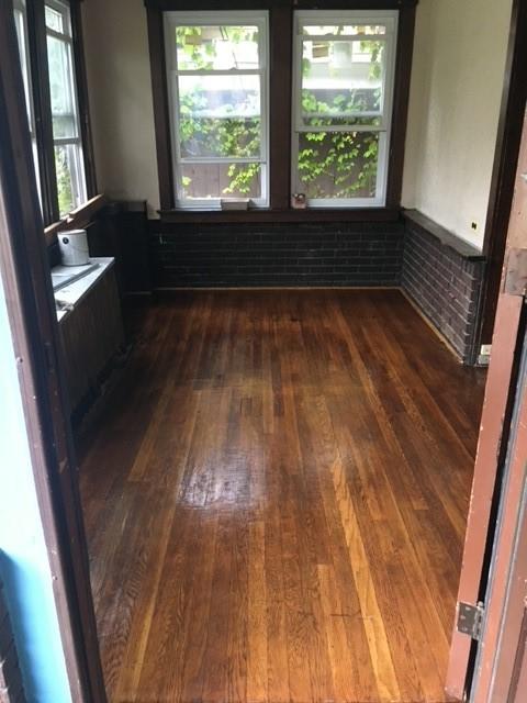 spare room with a healthy amount of sunlight and dark wood finished floors