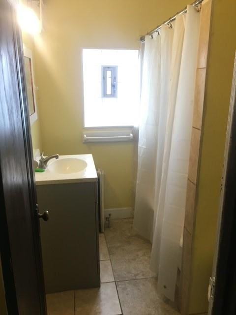 full bathroom with a shower with shower curtain, tile patterned flooring, vanity, and radiator