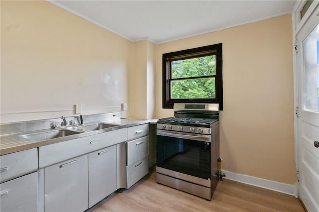 7807 Union Ave, Swissvale, PA 15218 - kitchen featuring stainless steel range with gas cooktop, light wood-style floors, stainless steel counters, and crown molding