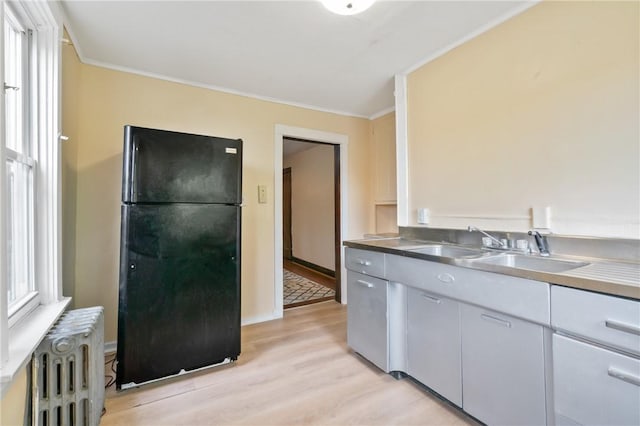 7807 Union Ave, Swissvale, PA 15218 - kitchen featuring freestanding refrigerator, radiator heating unit, light wood-type flooring, ornamental molding, and stainless steel counters
