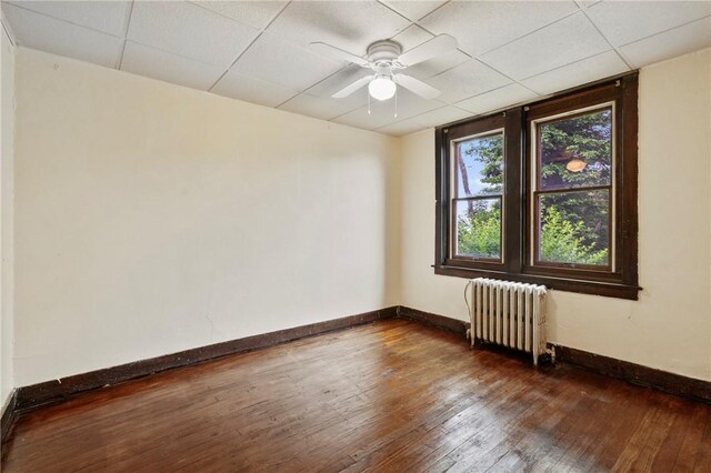 7807 Union Ave, Swissvale, PA 15218 - spare room featuring radiator heating unit, dark wood-style flooring, ceiling fan, and a drop ceiling