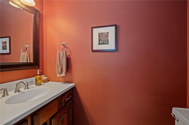 half bathroom featuring vanity and toilet