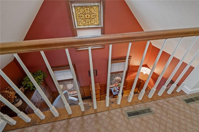 stairs featuring carpet, visible vents, and vaulted ceiling