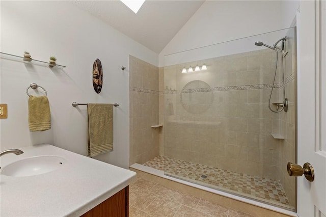 full bath with vaulted ceiling, tiled shower, tile patterned flooring, and vanity