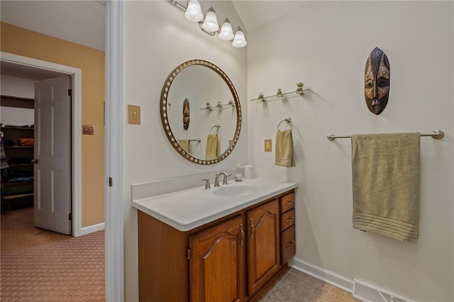 bathroom with baseboards, visible vents, and vanity