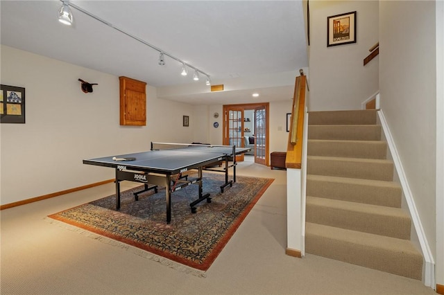 recreation room featuring french doors, rail lighting, and baseboards