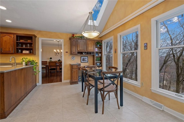 dining room featuring lofted ceiling, light tile patterned floors, baseboards, and visible vents