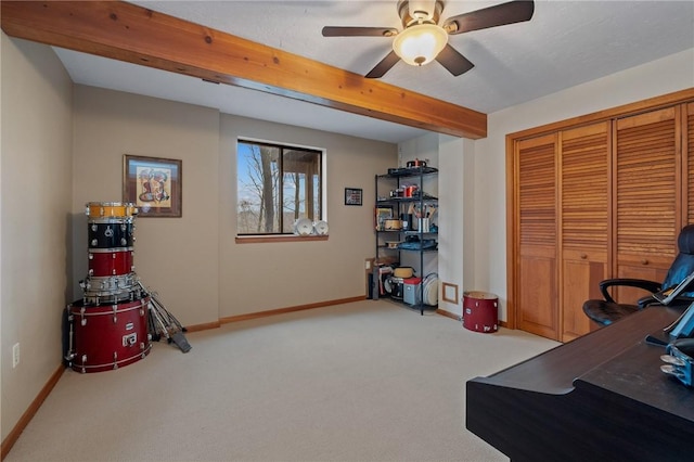 carpeted office featuring ceiling fan, baseboards, and beamed ceiling