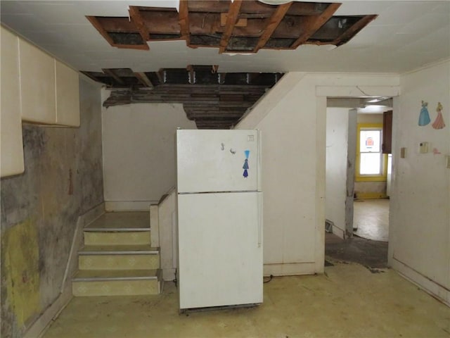 basement with stairway and freestanding refrigerator