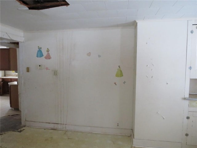 empty room with ornamental molding and unfinished concrete flooring