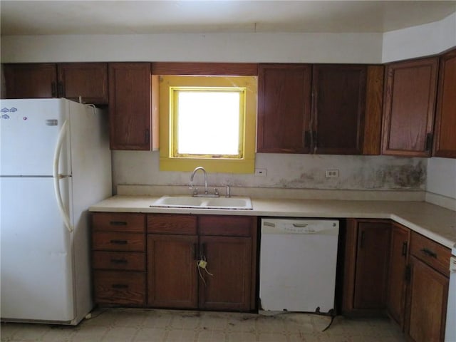 kitchen featuring white appliances, light floors, a sink, and light countertops