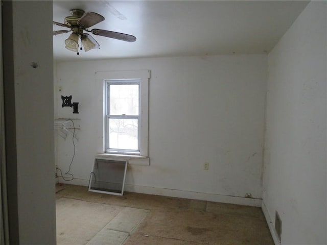 spare room with ceiling fan and baseboards