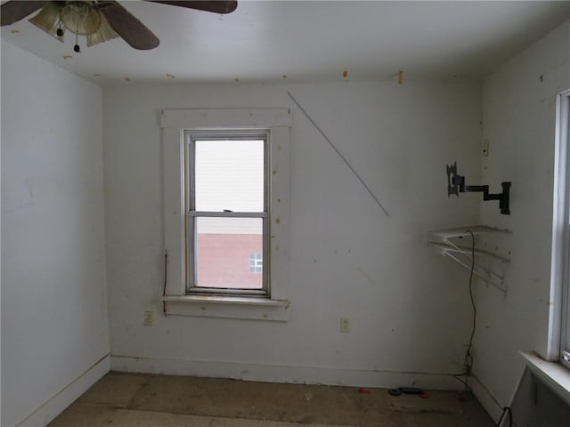 empty room featuring a ceiling fan and baseboards