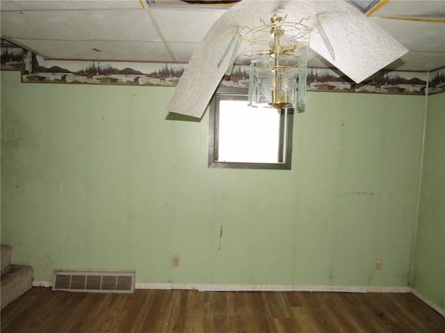 empty room with baseboards, stairs, visible vents, and wood finished floors