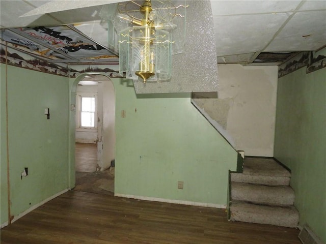 interior space with stairs, arched walkways, baseboards, and wood finished floors