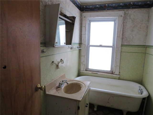 bathroom featuring a soaking tub and vanity