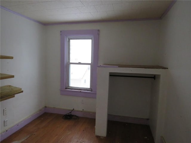 unfurnished living room with baseboards and wood finished floors